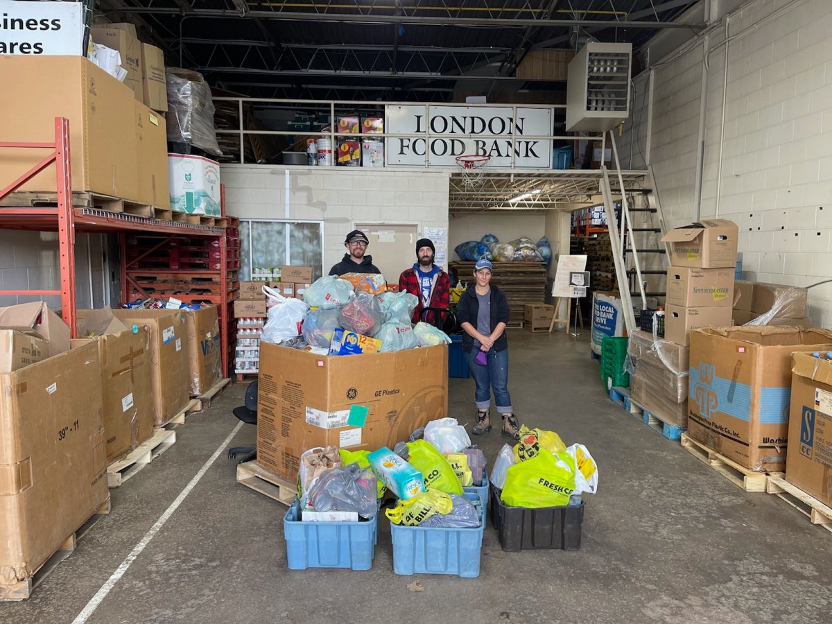 Sarah Appleby (right) stands alongside her neighbour Gary Saunders (centre) and her husband Thomas Jurisaga as they drop off more than 1,000 pounds of donations to the London Food Bank.