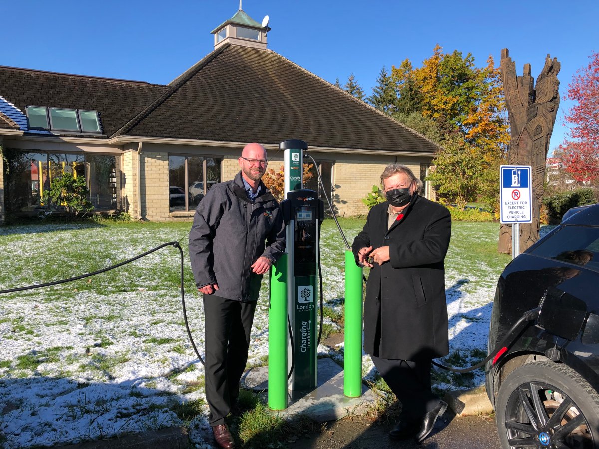 ChargerCrew Canada's manager of electromobility Jurgen van Dijken (left) and Mayor Ed Holder pose alongside a Level 2 electric vehicle charging station outside of Tourism London's Welcome Centre.