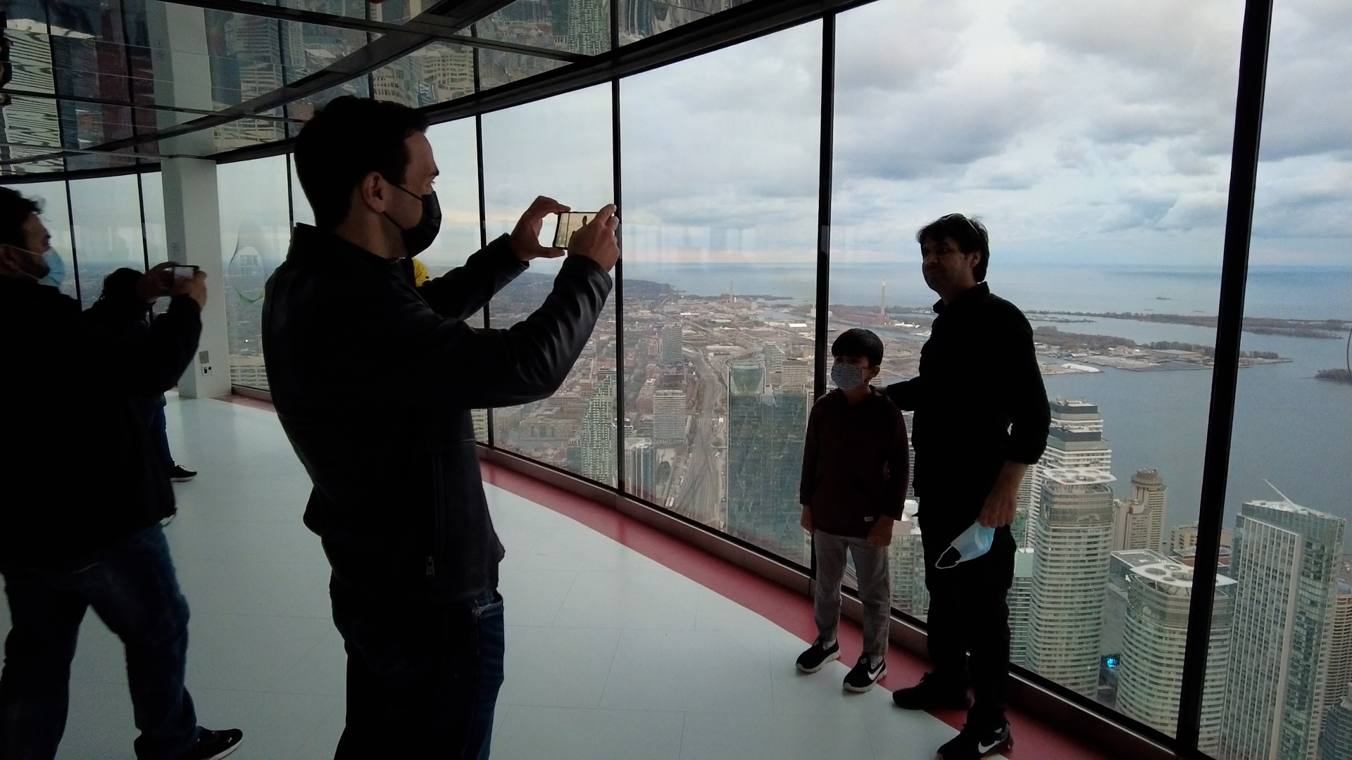 Mohammad Ismail and his eight-year-old son Himat get their photo taken inside the CN Tower.