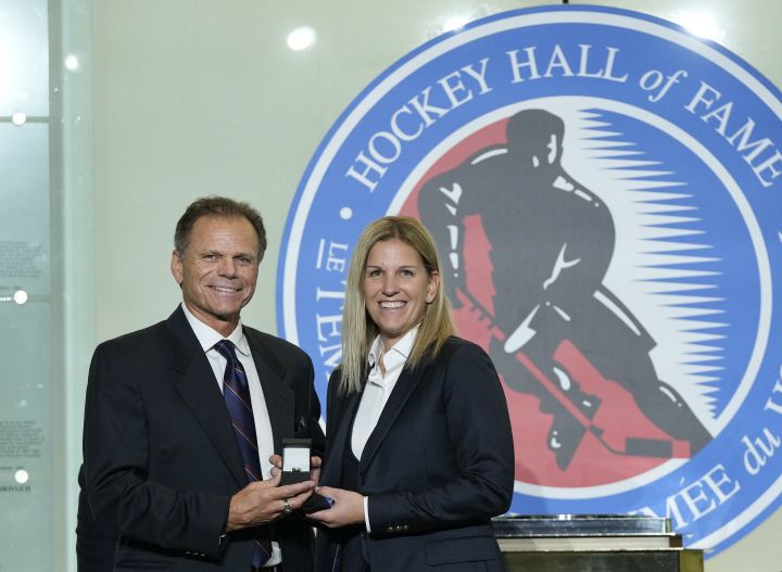 Mike Gartner, left, gives a ring to Hockey Hall of Fame inductee Kim St-Pierre in Toronto, Friday, Nov. 12, 2021.