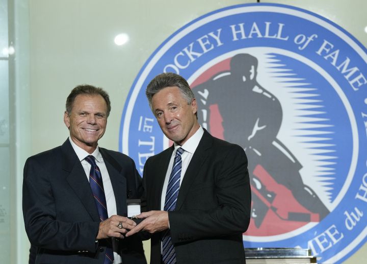 Mike Gartner, left, gives a ring to Hockey Hall of Fame inductee Doug Wilson in Toronto, Friday, Nov. 12, 2021.