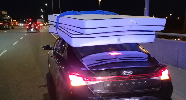 A photo of the vehicle with two mattresses secured by a bedsheet.