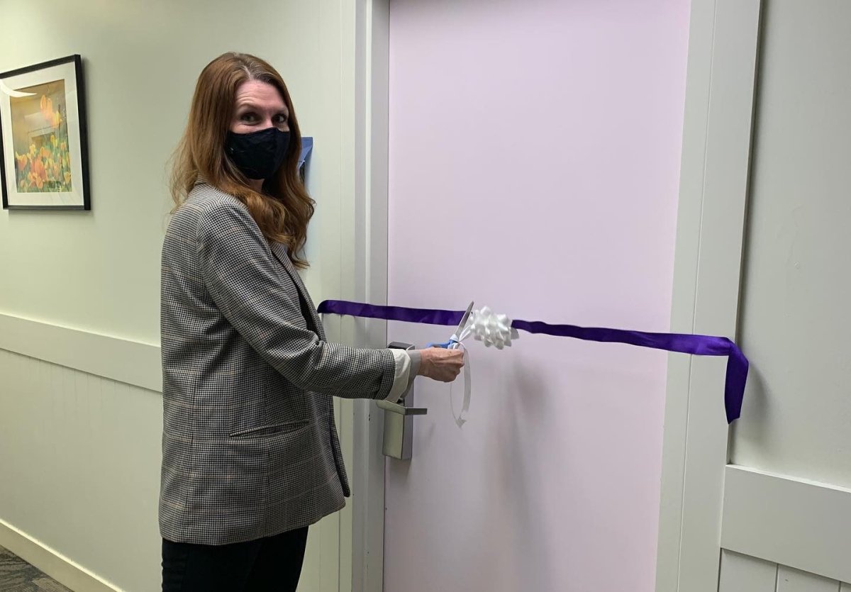 Kim Blankert, Jasmine Lovett's mom and Aliyah Sanderson's grandma, cuts the ribbon on a room honouring Lovett and Sanderson at the Calgary Women's Emergency Shelter.