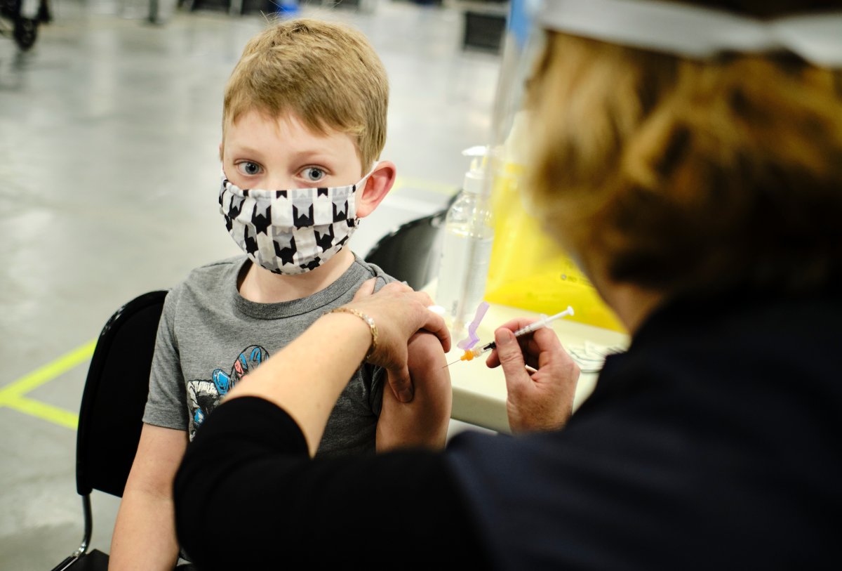 Eric Vernooy, age eight, gets his COVID-19 vaccine inside the COVID-19 vaccination clinic at the Nepean Sportsplex in Ottawa Friday, November 26, 2021.