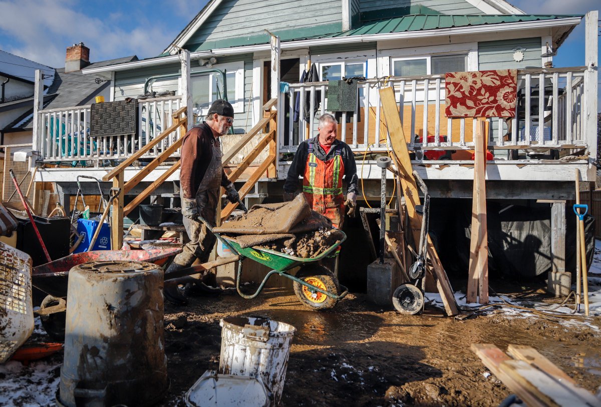 Home owner Brian Quinn, left, cleans up his flooded home with friend Lloyd Allen, after flooding in Princeton, B.C., Saturday, Nov. 20, 2021.