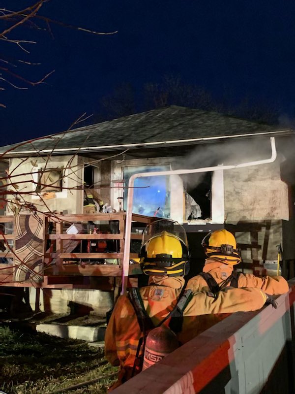 Firefighters observe damage to a North Central home in Regina after a fire occurred on Thursday morning.