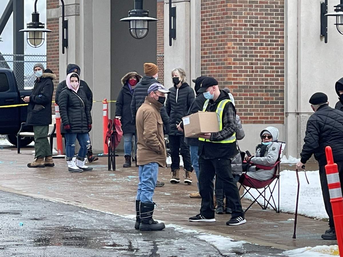 A staff member in a security uniform began distributing tests to select members of the queue about an hour before opening.