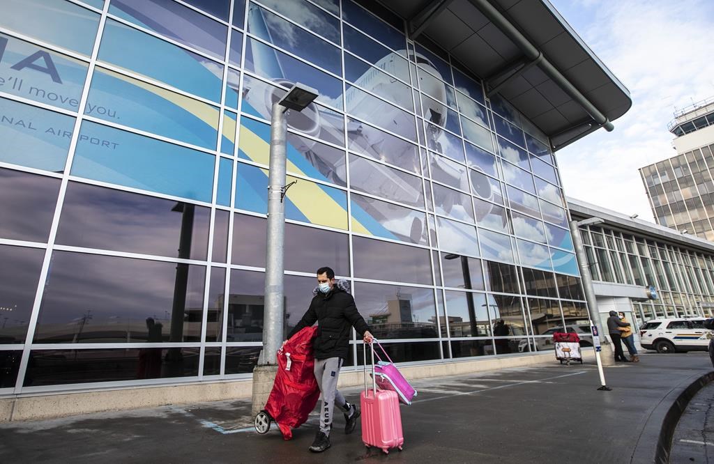 A traveller carrying luggage into the Edmonton International Airport on Thursday, Dec. 2, 2021. Passenger numbers doubled at YEG between 2021 and 2022.