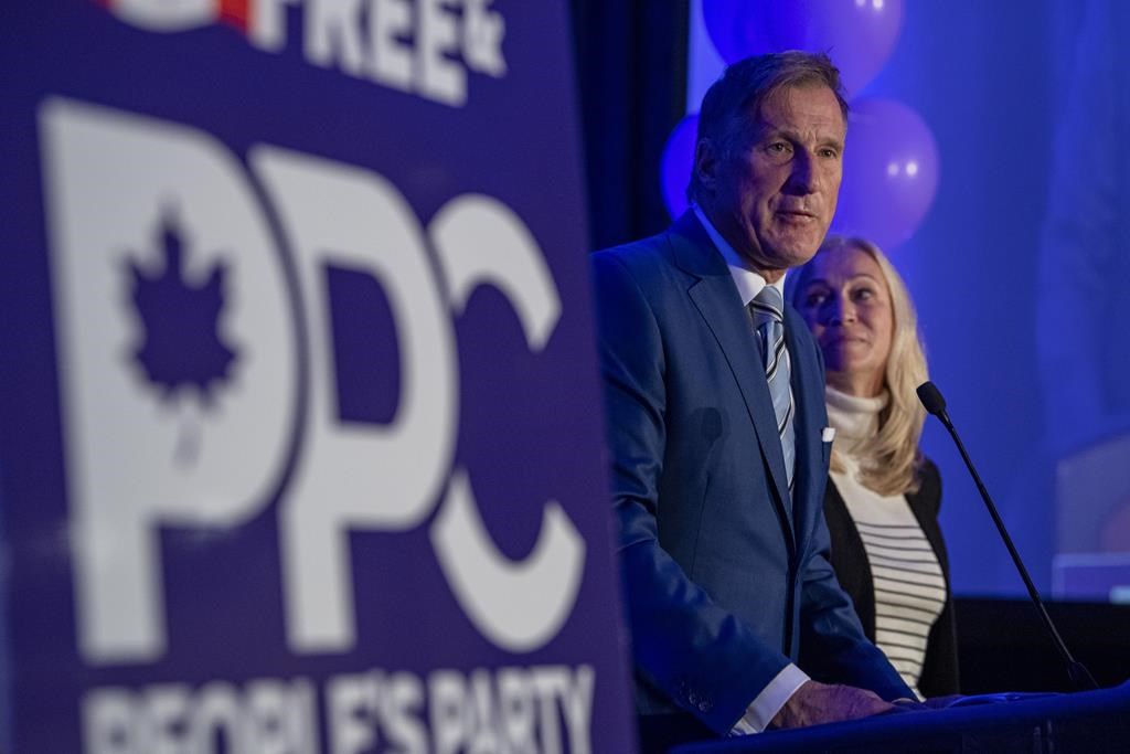 People's Party of Canada Leader Maxime Bernier and wife Catherine Letarte speaks from a podium to supporters during the PPC headquarters election night event in Saskatoon, Sask., Monday, Sept. 20, 2021. 