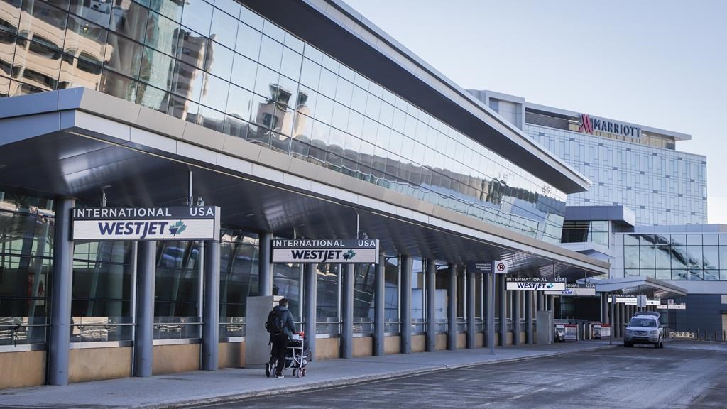 A lone traveler enters the Calgary International Airport on Monday, Feb. 22, 2021. THE CANADIAN PRESS/Jeff McIntosh.