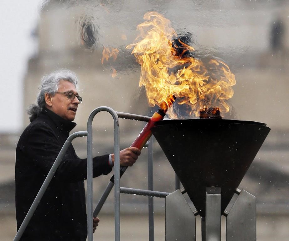 Elder Dave Courchene, seen here lighting the Centennial Torch during a lighting ceremony at the Manitoba Legislature in 2017, has died.