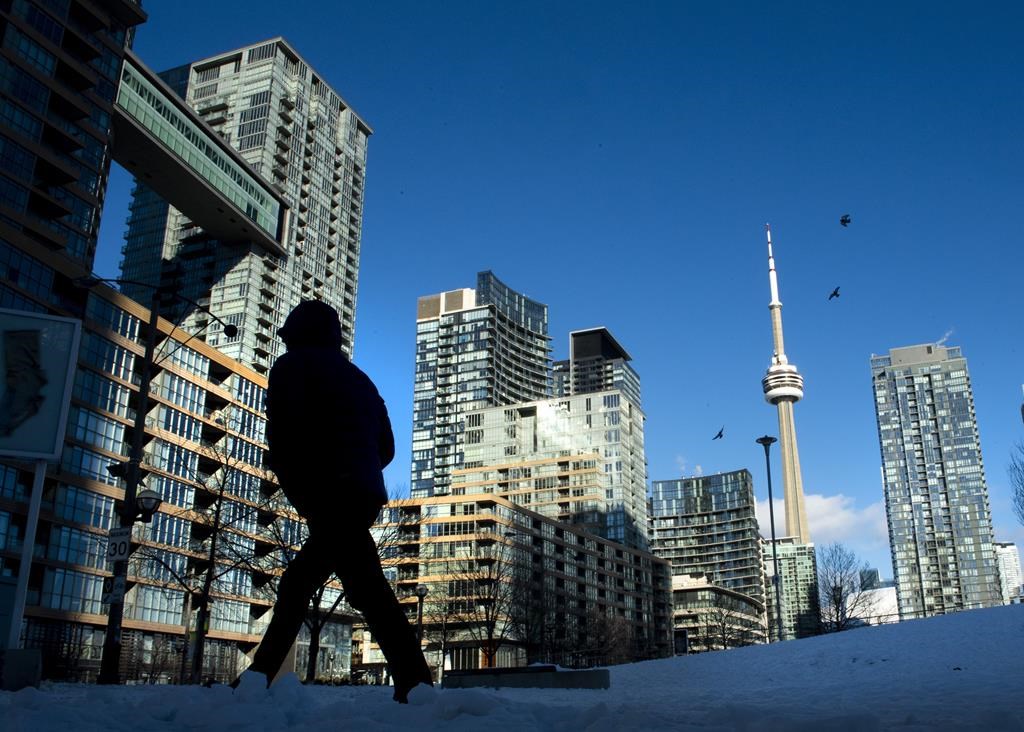 Condo towers dot the Toronto skyline as a pedestrian makes his way through the COVID-19 restricted winter landscape on January 28, 2021. THE CANADIAN PRESS/Frank Gunn.