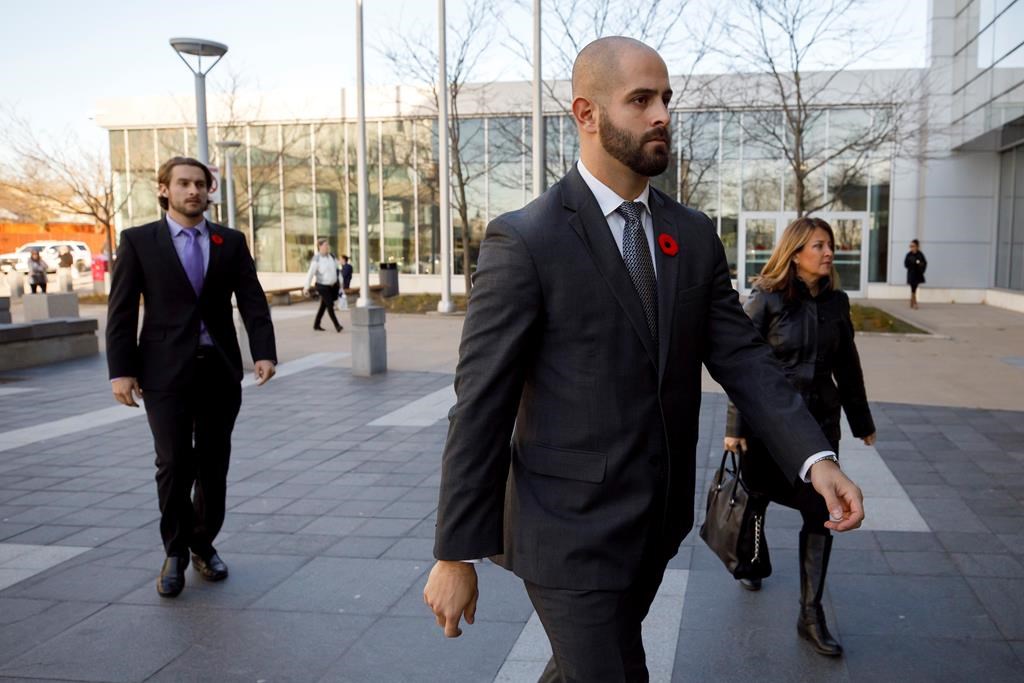 Michael Theriault, centre, and Christian Theriault, left, arrive at the Durham Region Courthouse in Oshawa, Ont. on Wednesday, Nov. 6, 2019. 