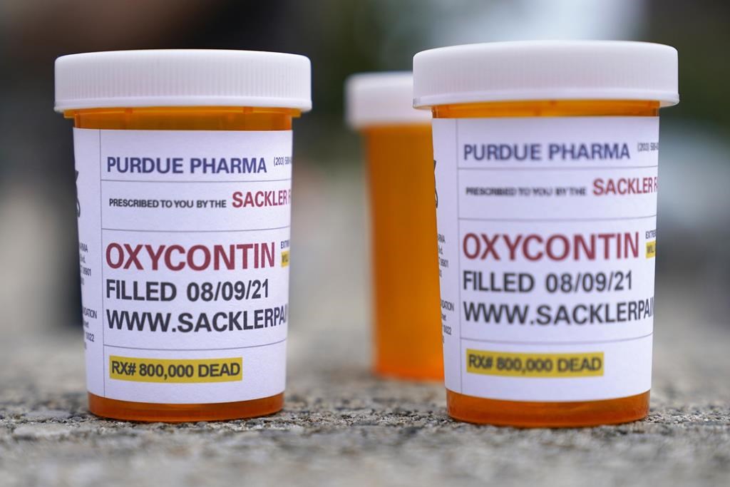 FILE - In this Aug. 9, 2021, file photo, fake pill bottles with messages about OxyContin maker Purdue Pharma are displayed during a protest outside the courthouse where the bankruptcy of the company is taking place in White Plains, N.Y. A federal judge on Thursday, Dec. 16, 2021, has rejected OxyContin maker Purdue Pharma’s bankruptcy settlement of thousands of lawsuits over the opioid epidemic because of a provision that would protect members of the Sackler family from facing litigation of their own. (AP Photo/Seth Wenig, File).