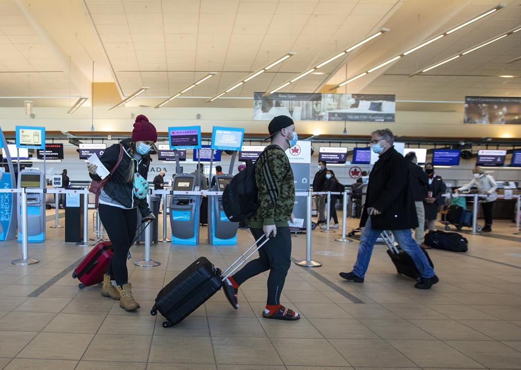 Travellers carry luggage to their flights at the Edmonton International Airport in Edmonton on Thursday, Dec. 2, 2021. Travellers can now pre-book their spots in the security line at EIA.