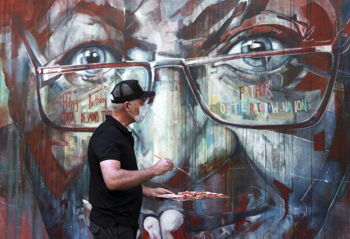 A wall mural, depicting Anglican Archbishop Emeritus, Desmond Tutu, is restored by the artist Brian Rolfe after it was defaced, in Cape Town, South Africa Thursday Oct. 7, 2021.