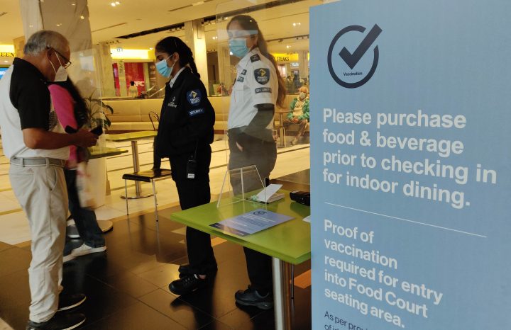 Customers show their proof of COVID-19 vaccination before entering the seating area of a food court at a shopping centre in Mississauga on Oct. 7, 2021.