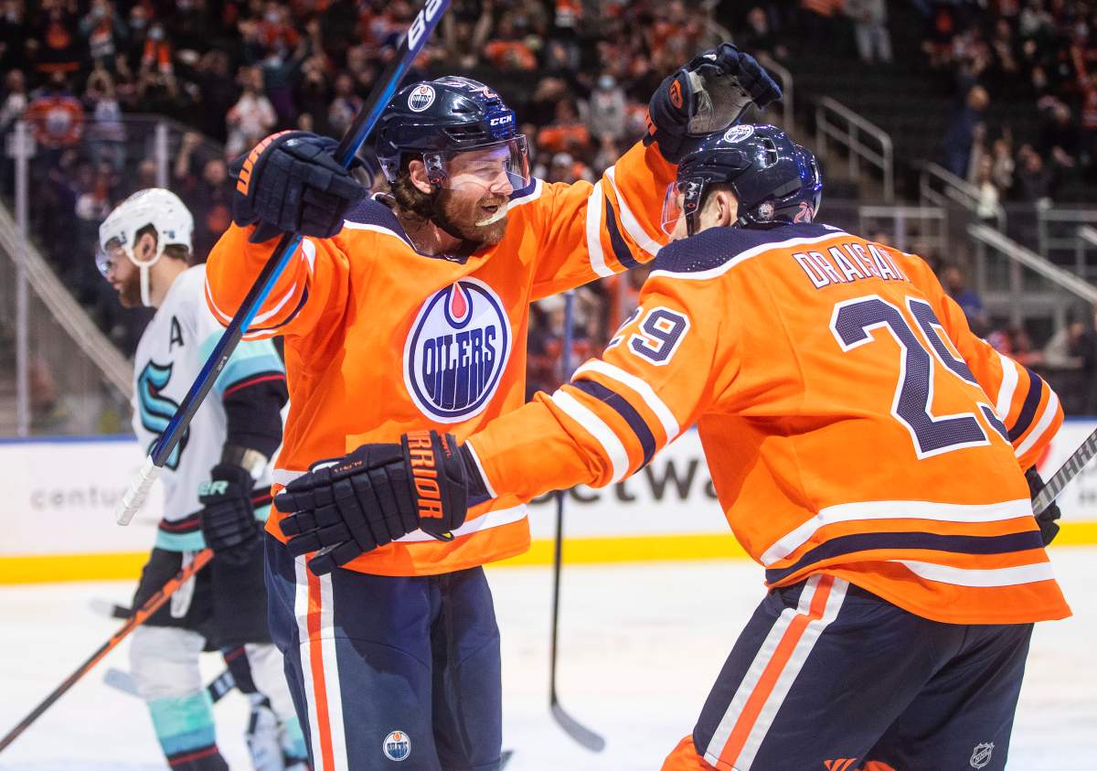 Seattle Kraken’s Adam Larsson (6) skates past as Edmonton Oilers’ Duncan Keith (2) and Leon Draisaitl (29) celebrate a goal during second period NHL action in Edmonton, Monday, Nov. 1, 2021. THE CANADIAN PRESS/Jason Franson