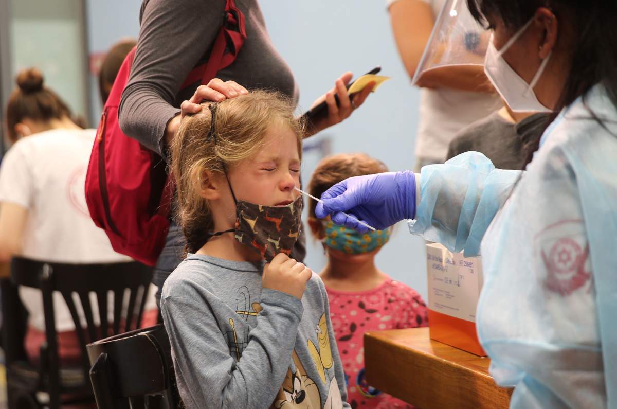 November 29, 2021, Jerusalem, Israel: A medical worker collects a nasal swab sample for COVID-19 test from a young girl at a COVID-19 testing center in Jerusalem. 