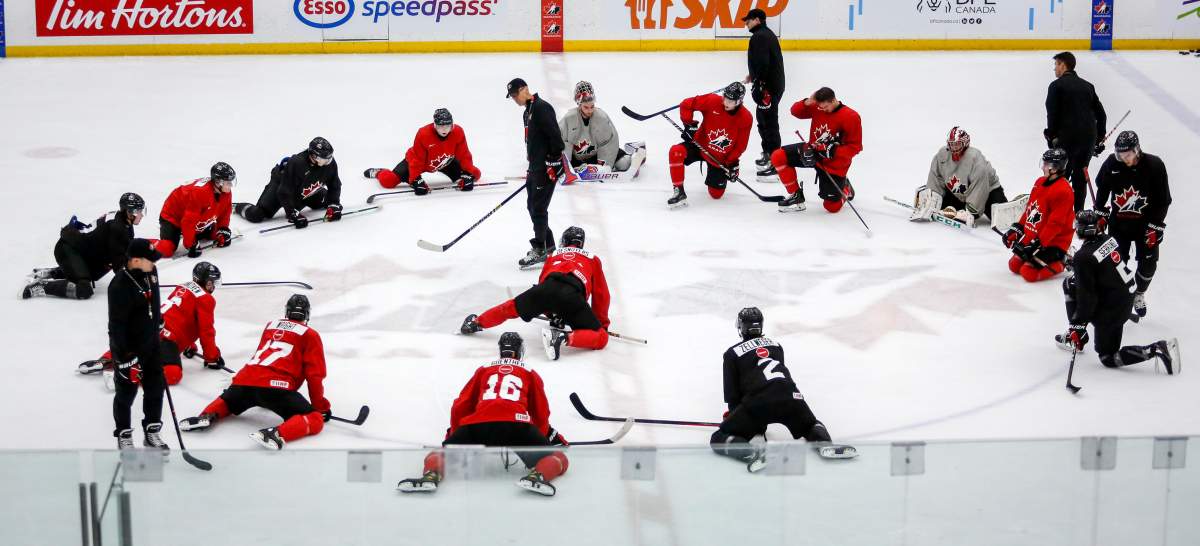 Players stretch as head coach Dave Cameron, centre left, gives instruction during a practice at the Canadian World Junior Hockey Championships selection camp in Calgary, Thursday, Dec. 9, 2021.