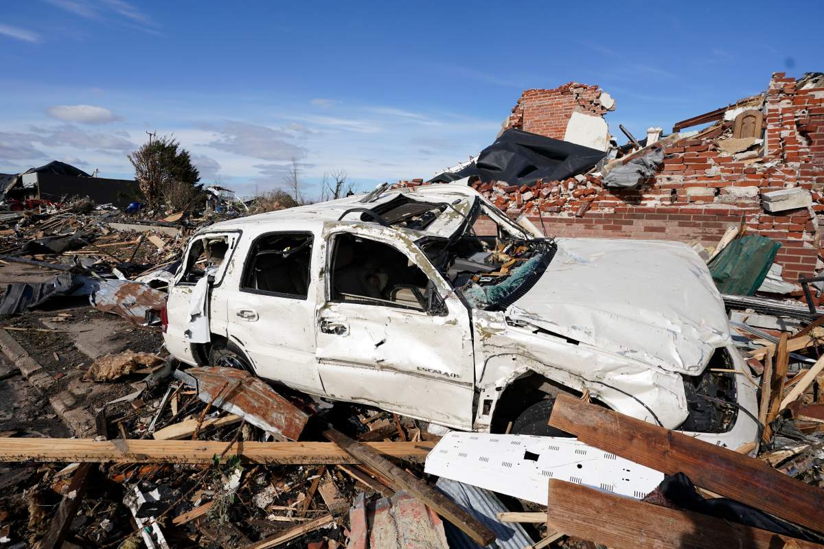 People survey damage from a tornado is seen in Mayfield, Ky., on Saturday, Dec. 11, 2021.