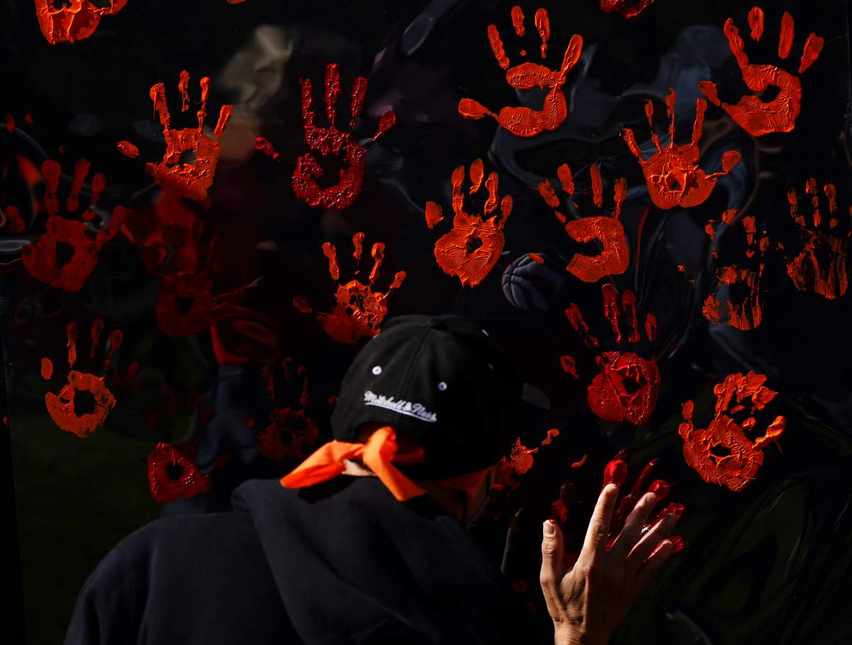 People contribute to a hand painting during the National Day for Truth and Reconciliation in Ottawa on Thursday, Sept. 30, 2021.