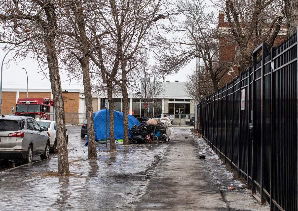 A tent and shopping carts line the street where homeless people are staying in Edmonton, Thursday, Dec. 9, 2021.
