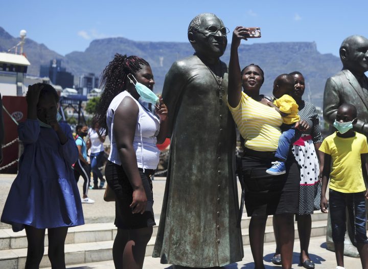 People take photos at a statue of Anglican Archbishop Desmond Tutu at the V&A Waterfront in Cape Town, South Africa, Sunday, Dec. 26, 2021.