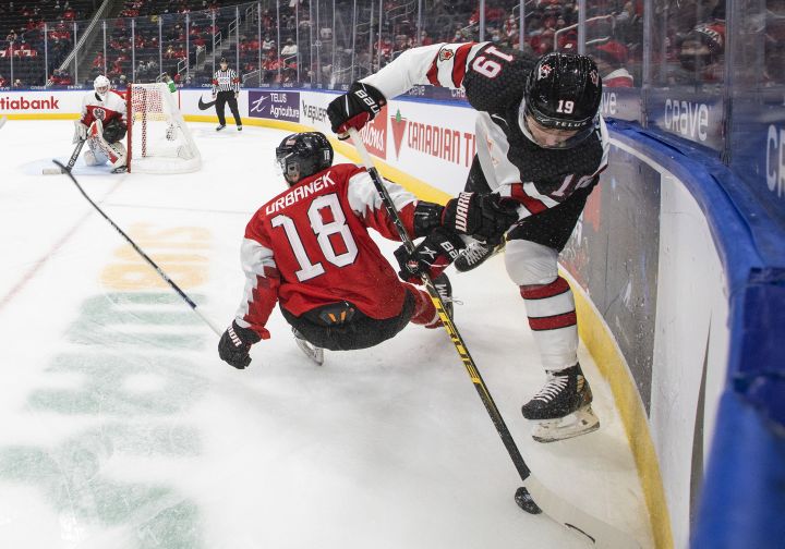 Canada’s Elliot Desnoyers (19) checks Austria’s Martin Urbanek (18) during second period IIHF World Junior Hockey Championship action in Edmonton on Tuesday, December 28, 2021.