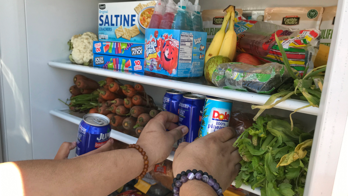 Volunteers stock a refrigerator with free food for people in need in Los Angeles on July 20, 2020. A network called LA Community Fridge has placed eight refrigerators across the Los Angeles area. 