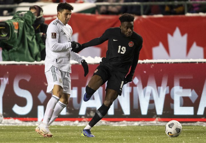 Canada’s Alphonso Davies (19) and Mexico’s Julio Cesar Domingguez Juarez (3) via for the ball during World Cup Qualifiers in Edmonton, Tuesday, Nov. 16, 2021.