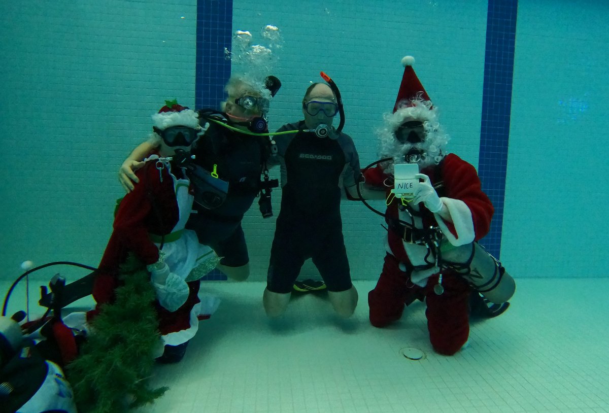 Mr. & Mrs. Claus taking underwater Christmas photos with a scuba diver.