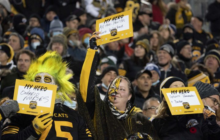 Fans hold up “My Hero” cards during second half CFL football game action between the Hamilton Tiger Cats and the BC Lions in Hamilton, Ont. on Friday, November 5, 2021.
