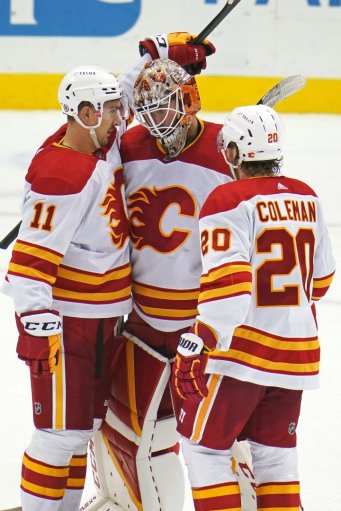 Calgary Flames goaltender Jacob Markstrom, center, celebrates his shutout of the Pittsburgh Penguins with Mikael Backlund (11) and Blake Coleman (20) at the end of an NHL hockey game in Pittsburgh, Thursday, Oct. 28, 2021.
