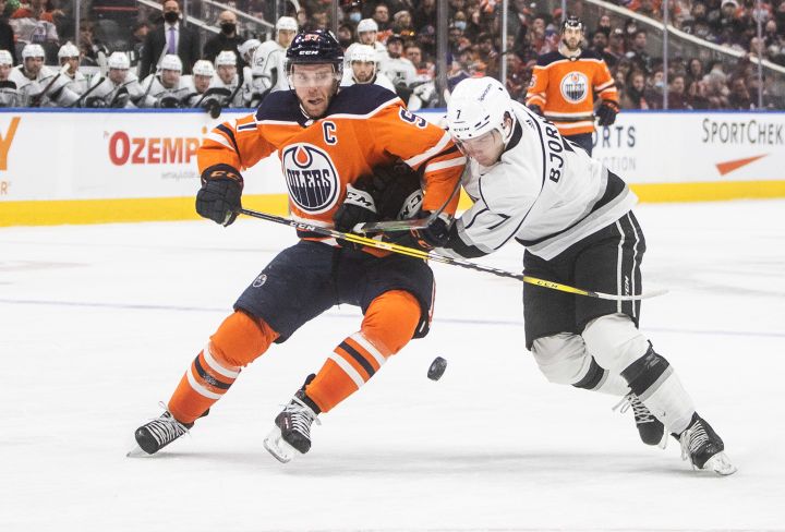 Los Angeles Kings’ Tobias Bjornfot (7) and Edmonton Oilers’ Connor McDavid (97) battle for the puck during second period NHL action in Edmonton, Sunday, Dec. 5, 2021.