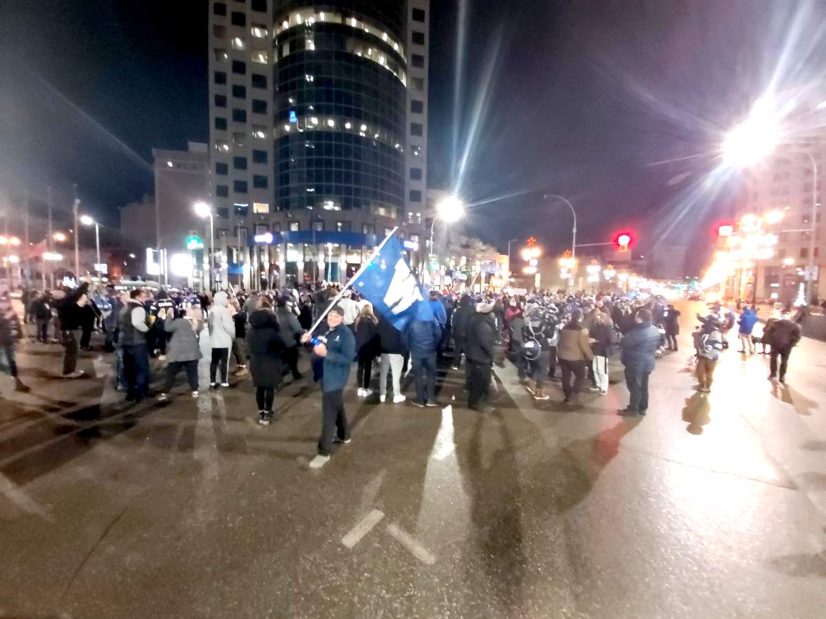 People gathered at Portage and Main after the Winnipeg Blue Bombers’ win Sunday, December 12, 2021.