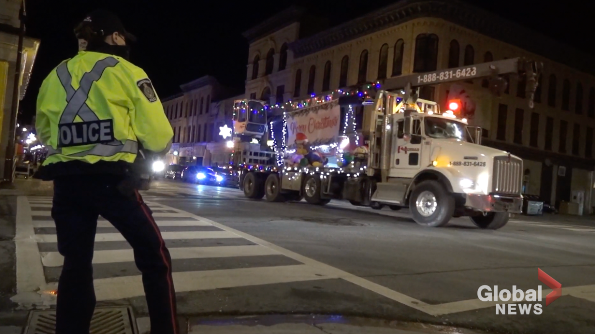 A Peterborough police officer watches parade of an unsanctioned parade on George St. on Saturday night.