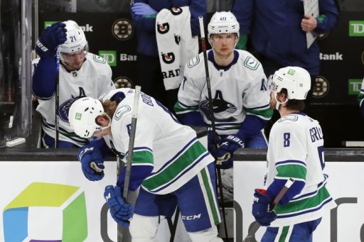Vancouver Canucks’ Brock Boeser (6) stands by the bench with teammates Nils Hoglander (21), Elias Pettersson (40) and Conor Garland (8) during an official review following a Boston Bruins goal that was disallowed in the third period of an NHL hockey game, Sunday, Nov. 28, 2021, in Boston.