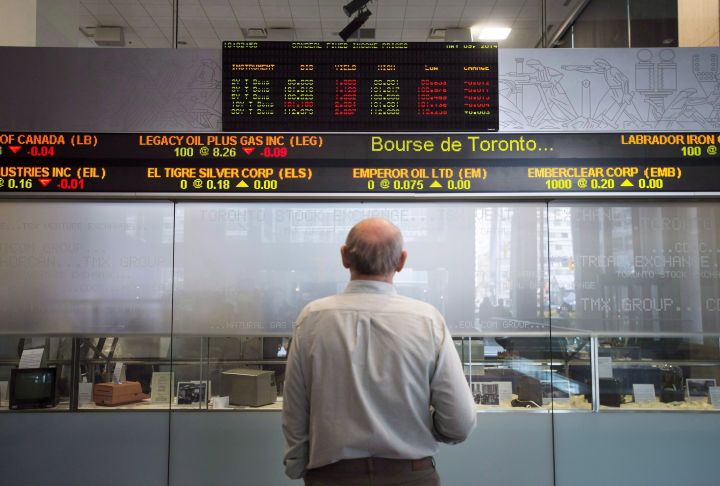 Canada's main stock index edged lower in late-morning trading as the industrials, financial and telecom sectors traded lower. A man watches the financial numbers on the digital ticker tape at the TMX Group in Toronto's financial district on Friday, May 9, 2014. 