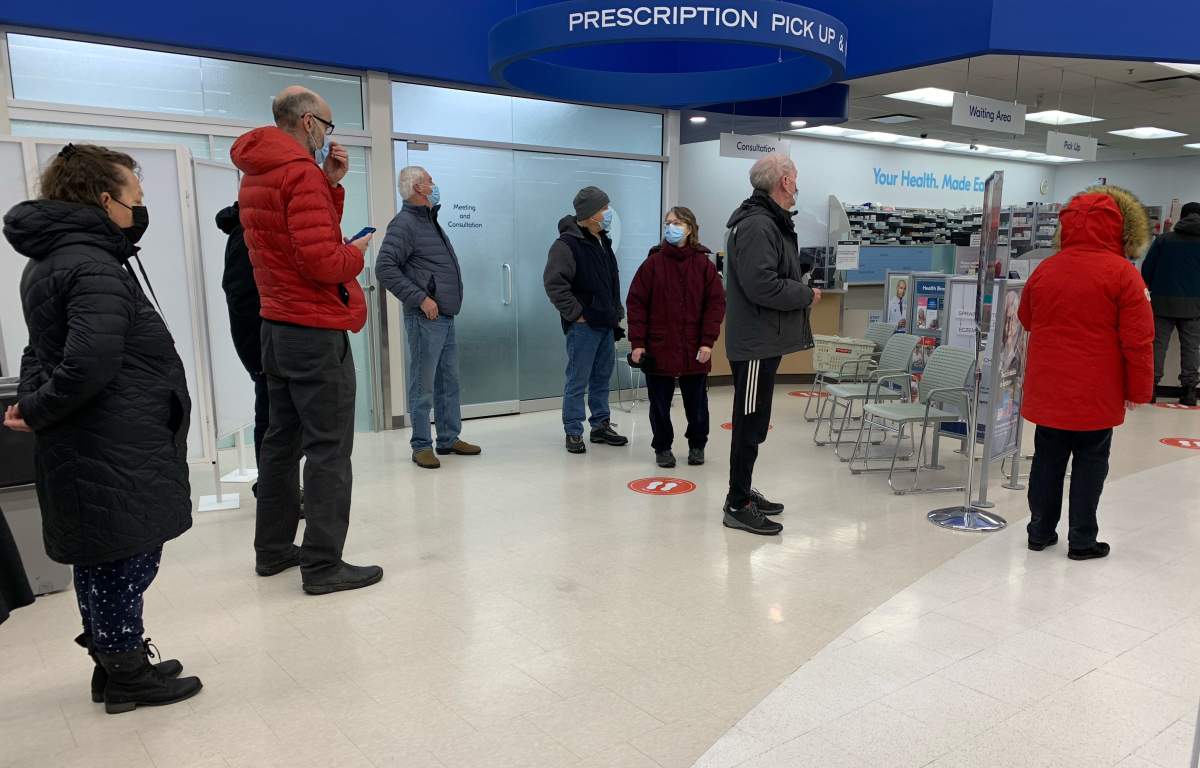 A lineup for free rapid antigen COVID-19 test kits outside a pharmacy in Calgary, Alta. on Friday, Dec. 17, 2021.