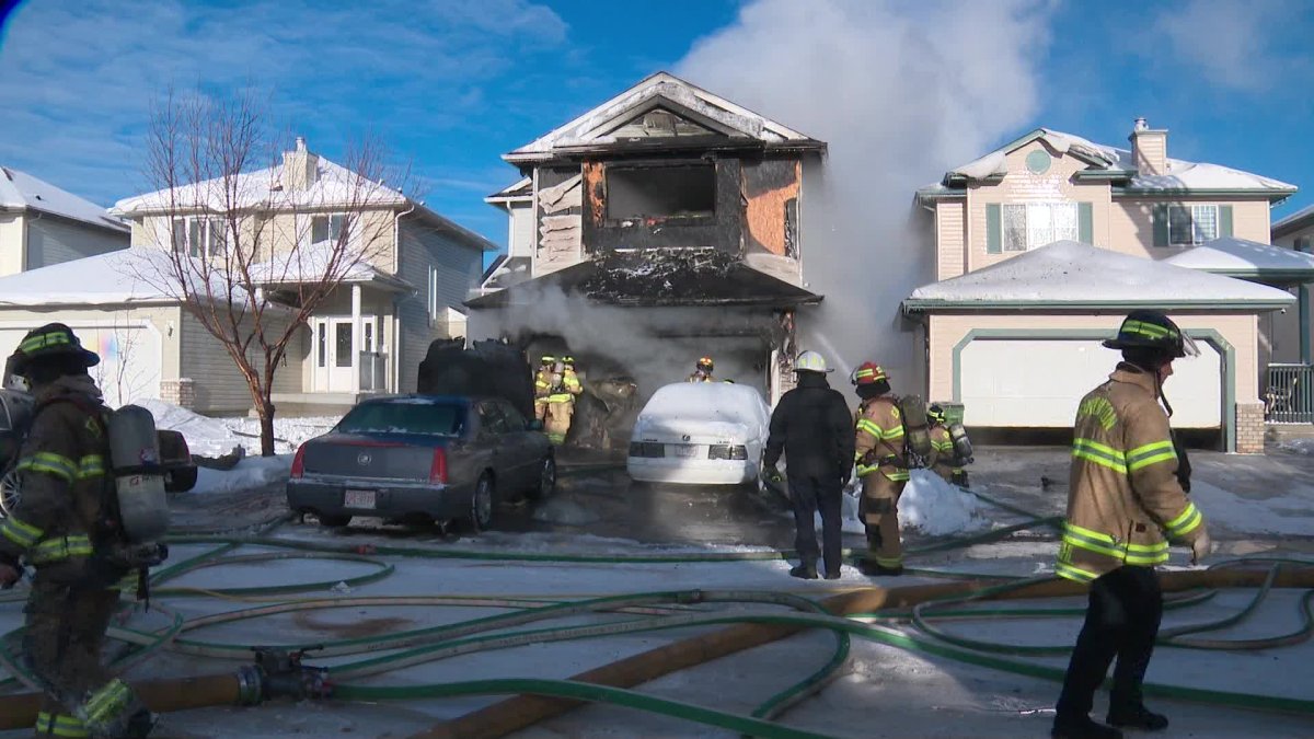 Fire crews respond to a house fire on Wyman Lane in the Wild Rose neighbourhood of Edmonton Monday, Dec. 20, 2021.
