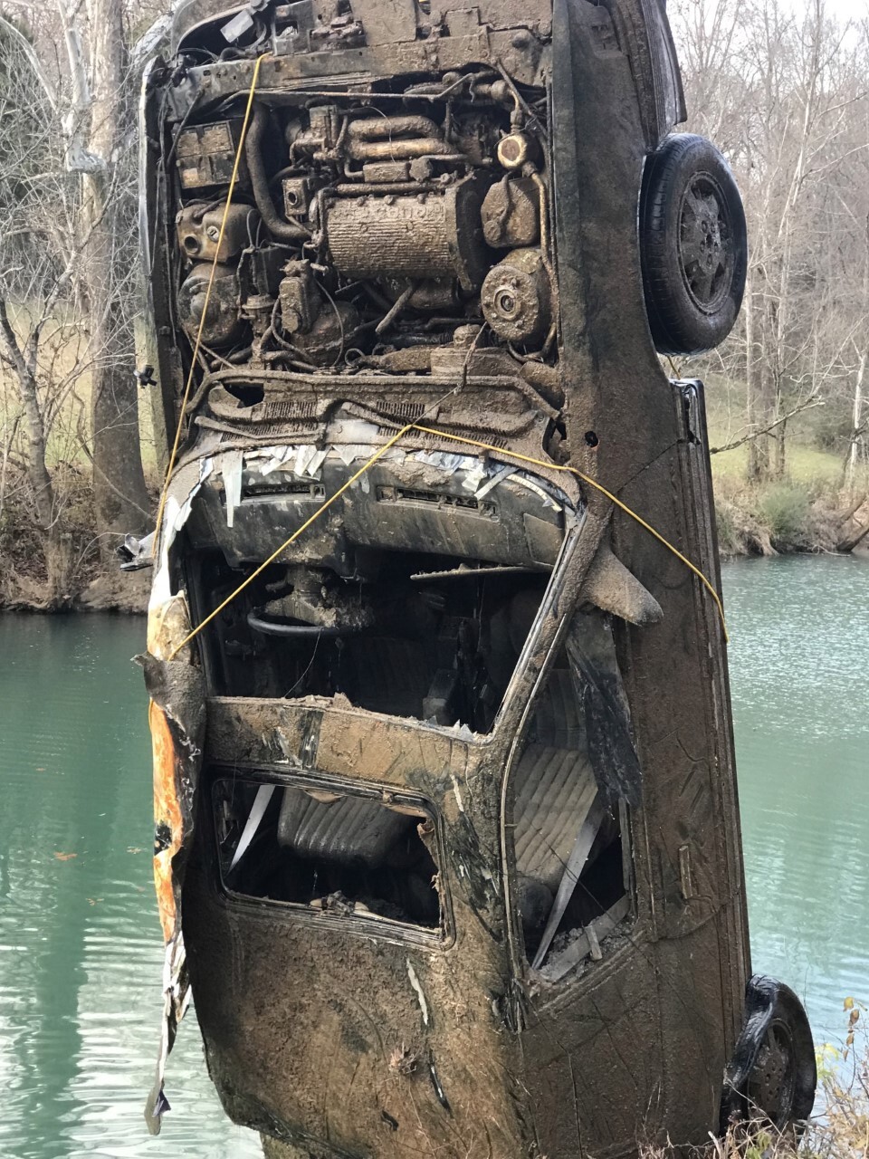 The car is covered in rust as its pulled from the river.