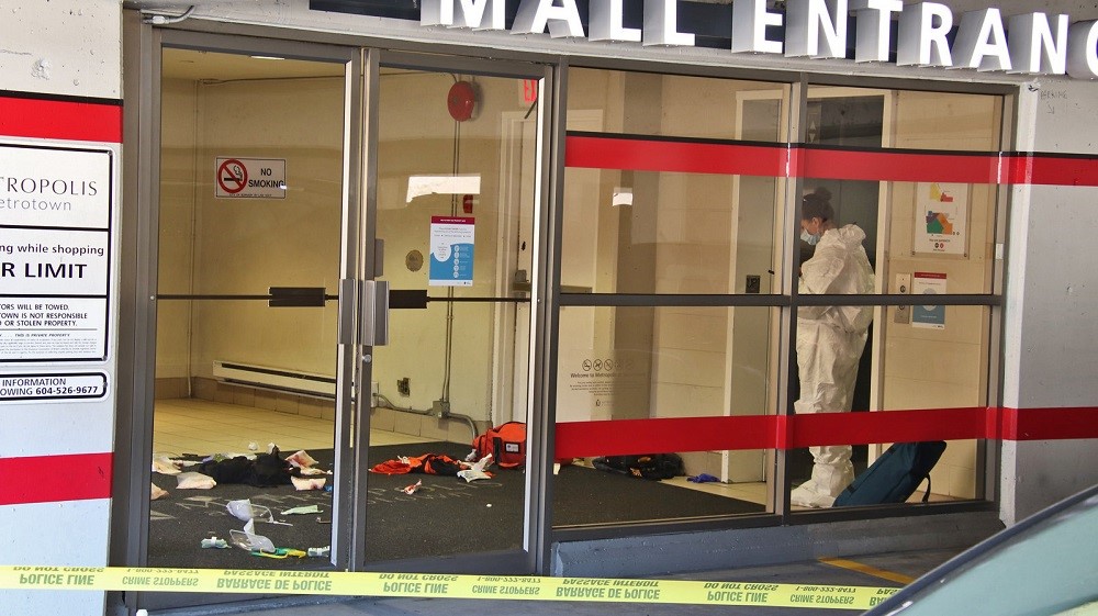 Investigators are seen at the entrance to Metropolis at Metrotown after one person was fatally stabbed on Sunday. 