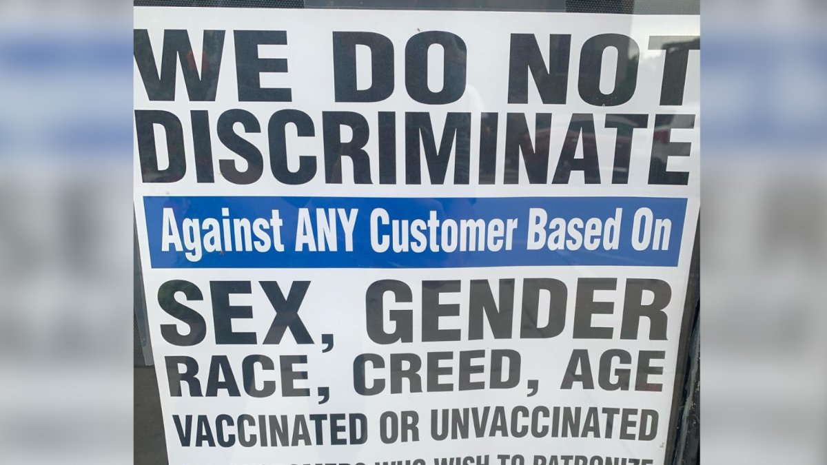 A sign posted out front of  Zucchinis Cucina in Oakville, Ontario. The province has suspended the eatery's liquor licence and is moving to revoke it after officers discovered it was not in complinace with the Ford government's proof-of-vaccination policy.