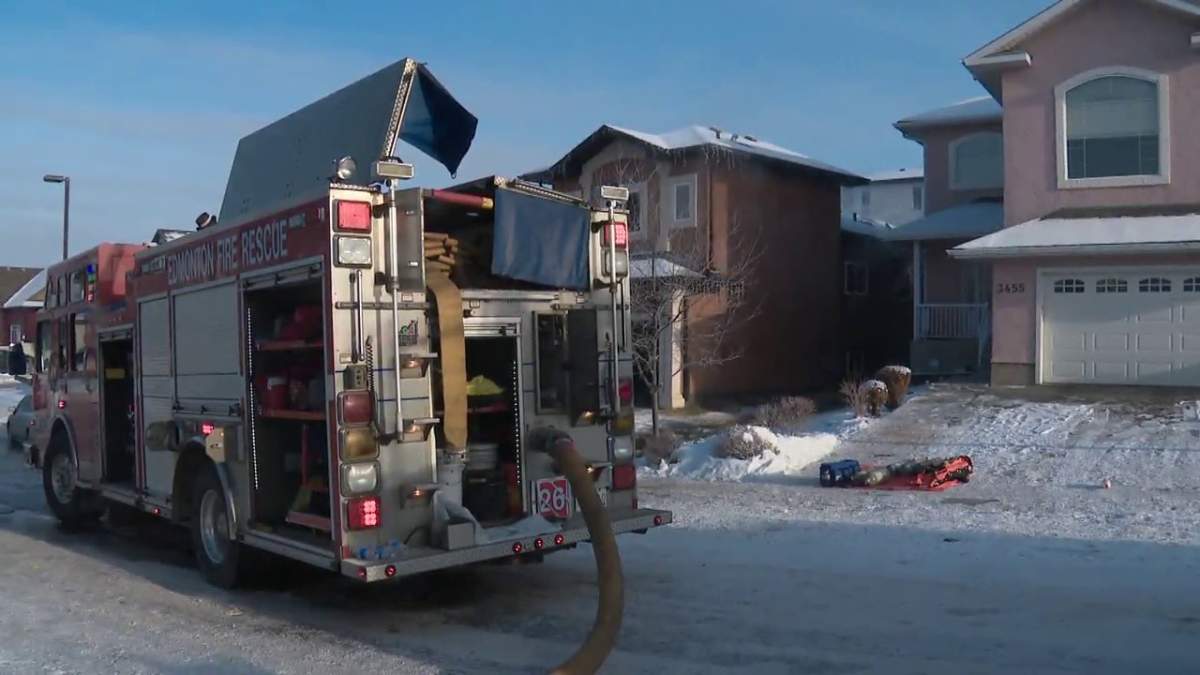 Firefighters battle a blaze at a house in the area of 34 Avenue and 29 Street in Edmonton Monday, Dec. 13, 2021.