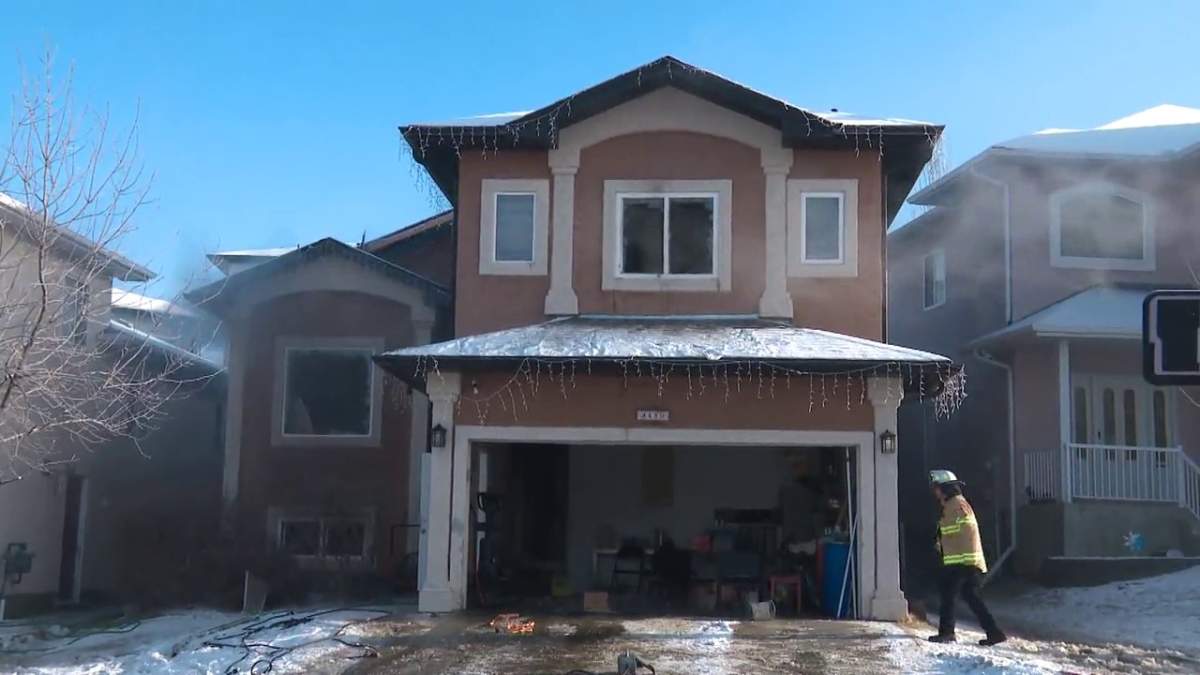 Firefighters battle a blaze at a house in the area of 34 Avenue and 29 Street in Edmonton Monday, Dec. 13, 2021.
