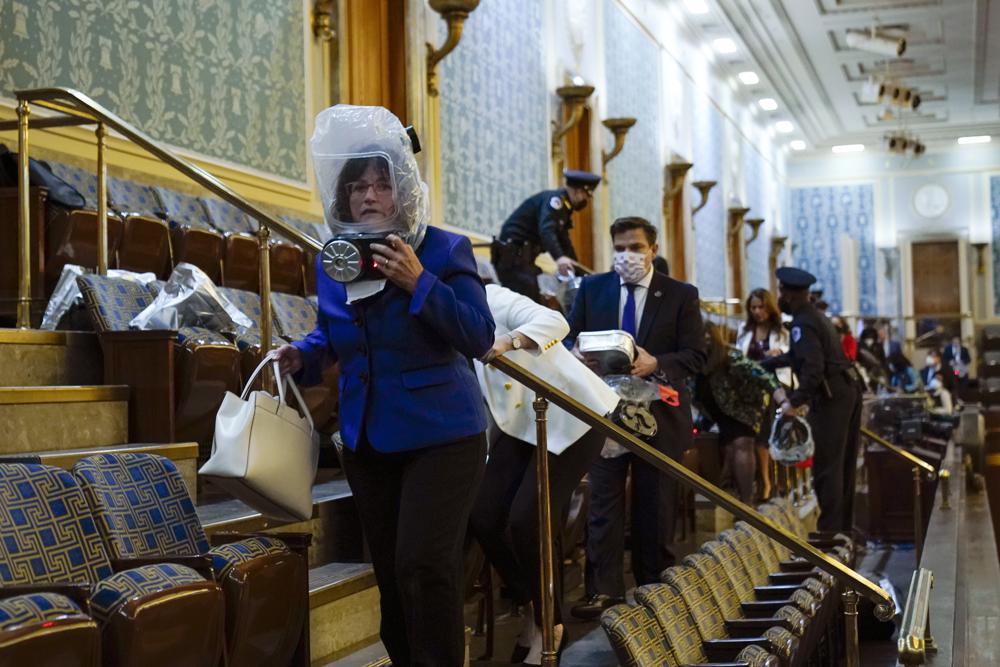 People shelter in the House gallery as rioters try to break into the House Chamber at the U.S. Capitol on Jan. 6, 2021, in Washington.
