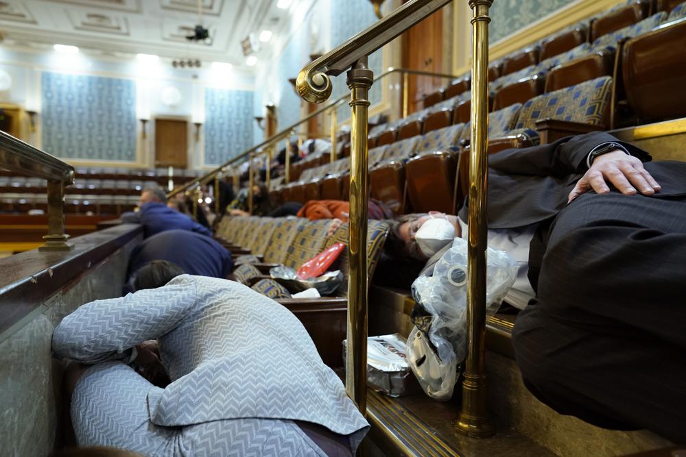 Members of Congress and others shelter in the House gallery as rioters try to break into the House Chamber at the U.S. Capitol on Jan. 6, 2021, in Washington.