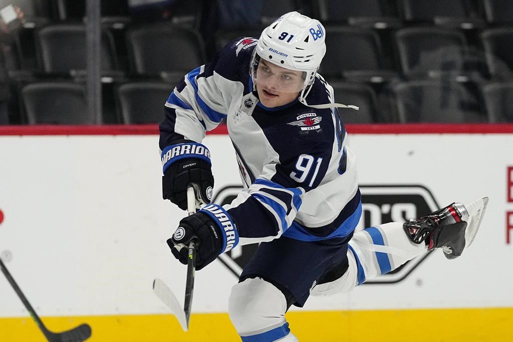 Winnipeg Jets forward Cole Perfetti shoots as players warm for an NHL hockey game against the Colorado Avalanche on Thursday, Jan. 6, 2022, in Denver.
