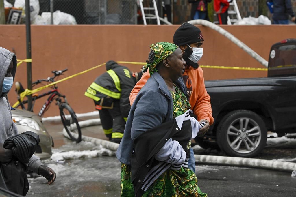 Residents leave their building during a high rise fire on East 181 Street, Sunday, Jan. 9, 2022, in the Bronx borough of New York.